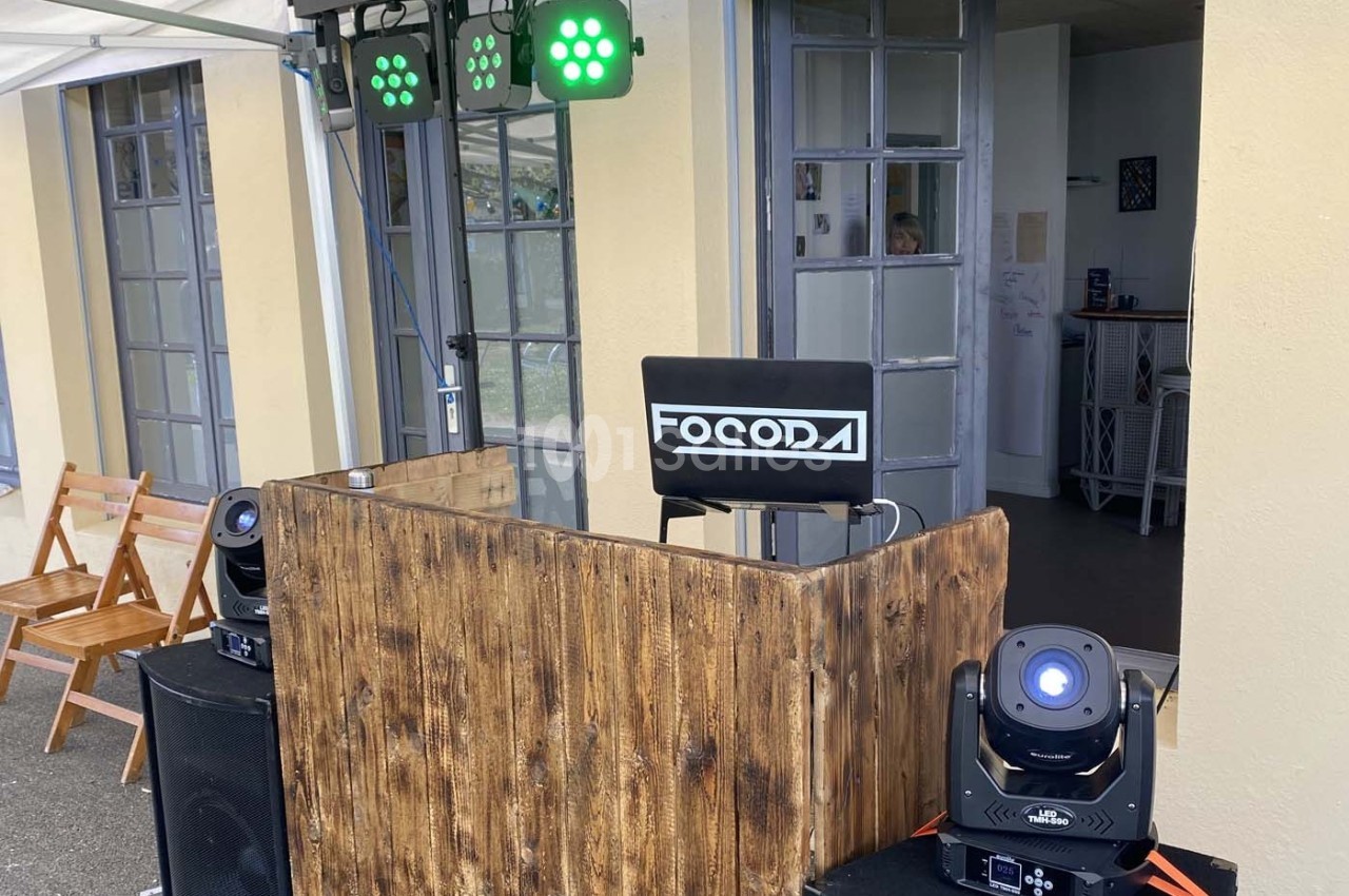 Installation de matériel de sonorisation et d'éclairage avec une table en bois et des projecteurs LED.