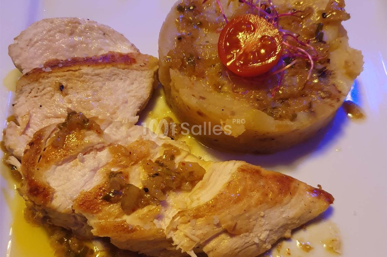 Assiette avec filet de poulet rôti, écrasé de pommes de terre aux herbes et tomate cerise en garniture.