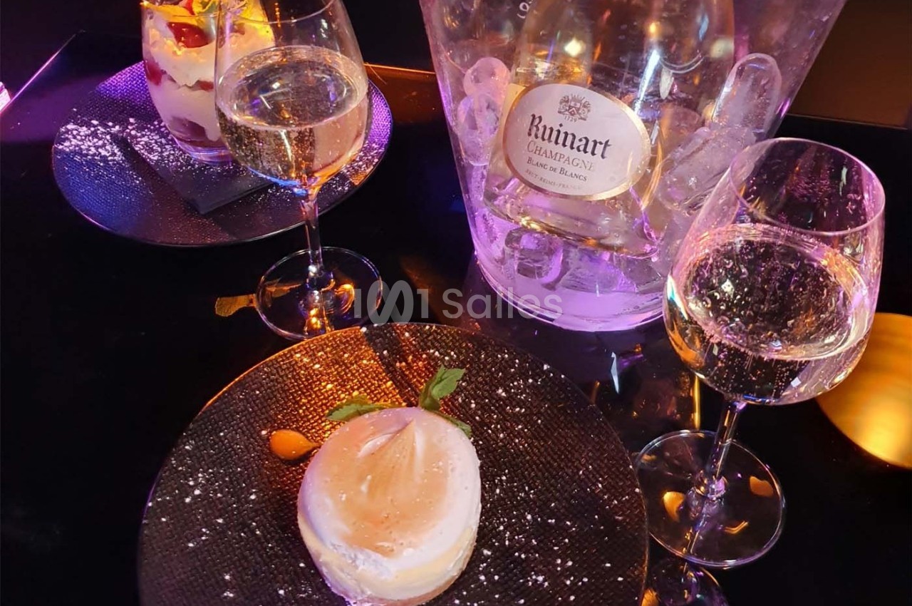 Deux desserts servis avec des verres de champagne et un seau à glace contenant une bouteille de Ruinart.