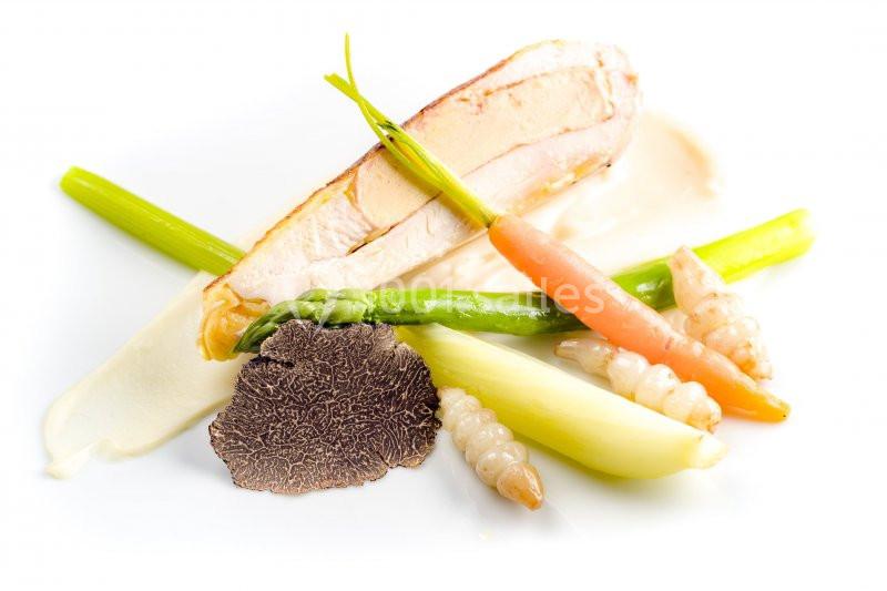 Assiette gastronomique avec filet de volaille, légumes croquants, purée et lamelle de truffe noire.