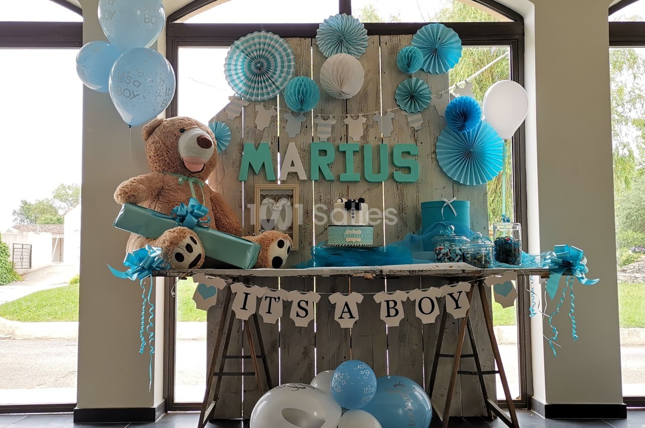 Décoration de fête sur le thème de la naissance d'un garçon avec ballons bleus, ours en peluche et guirlande ’It's a boy’.