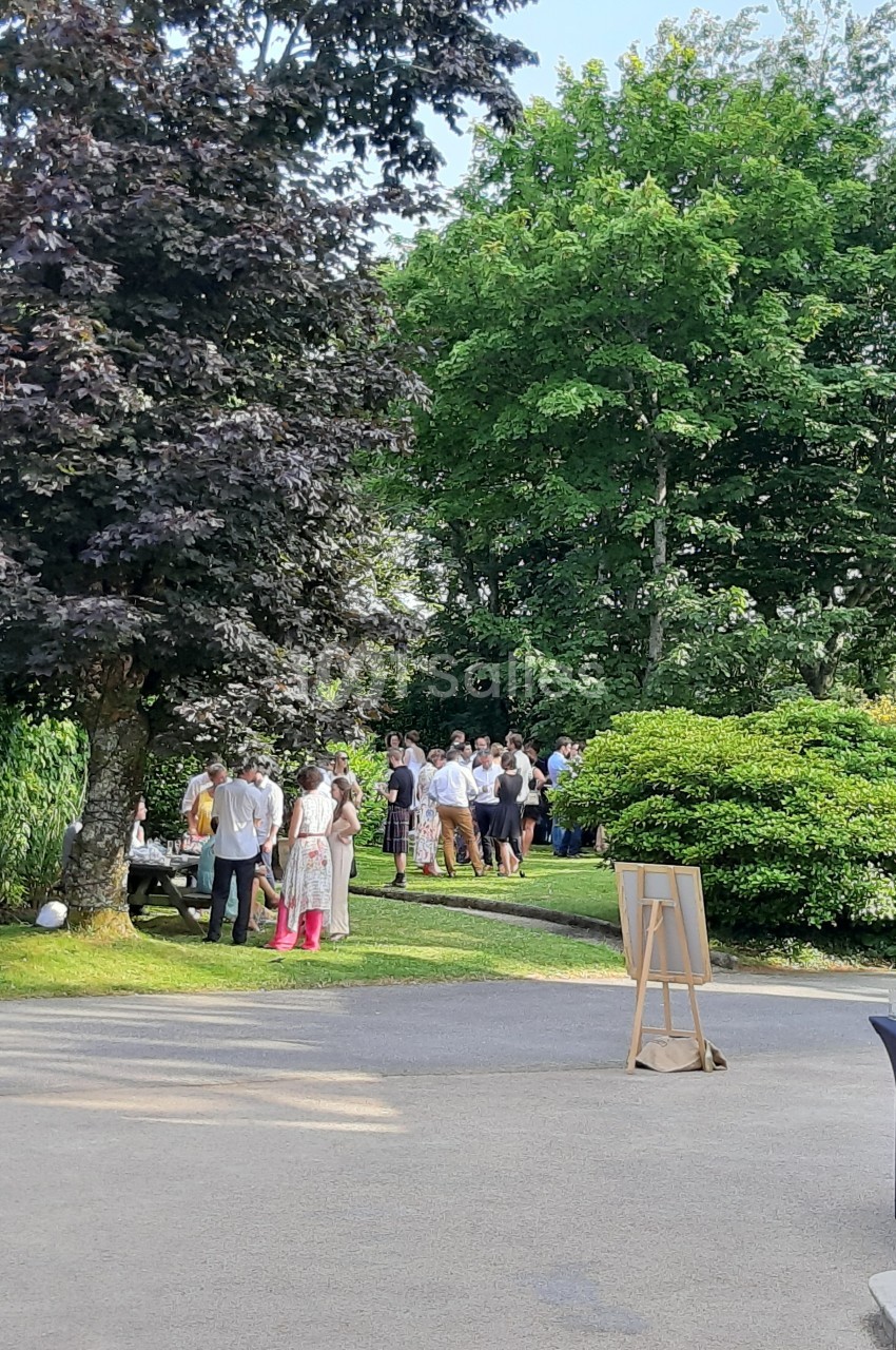 Un groupe de personnes discutant dans un jardin verdoyant par une journée ensoleillée.