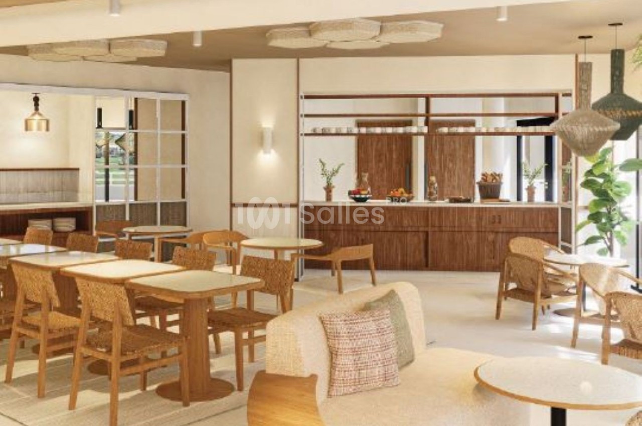 Espace intérieur lumineux avec tables basses en bois, chaises en rotin, banquettes et comptoir aux tons naturels.