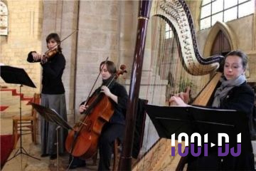 Trois musiciennes jouent du violon, du violoncelle et de la harpe dans un lieu à l'architecture en pierre.