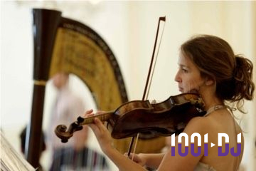 Une musicienne joue du violon devant une harpe dans une salle lumineuse.