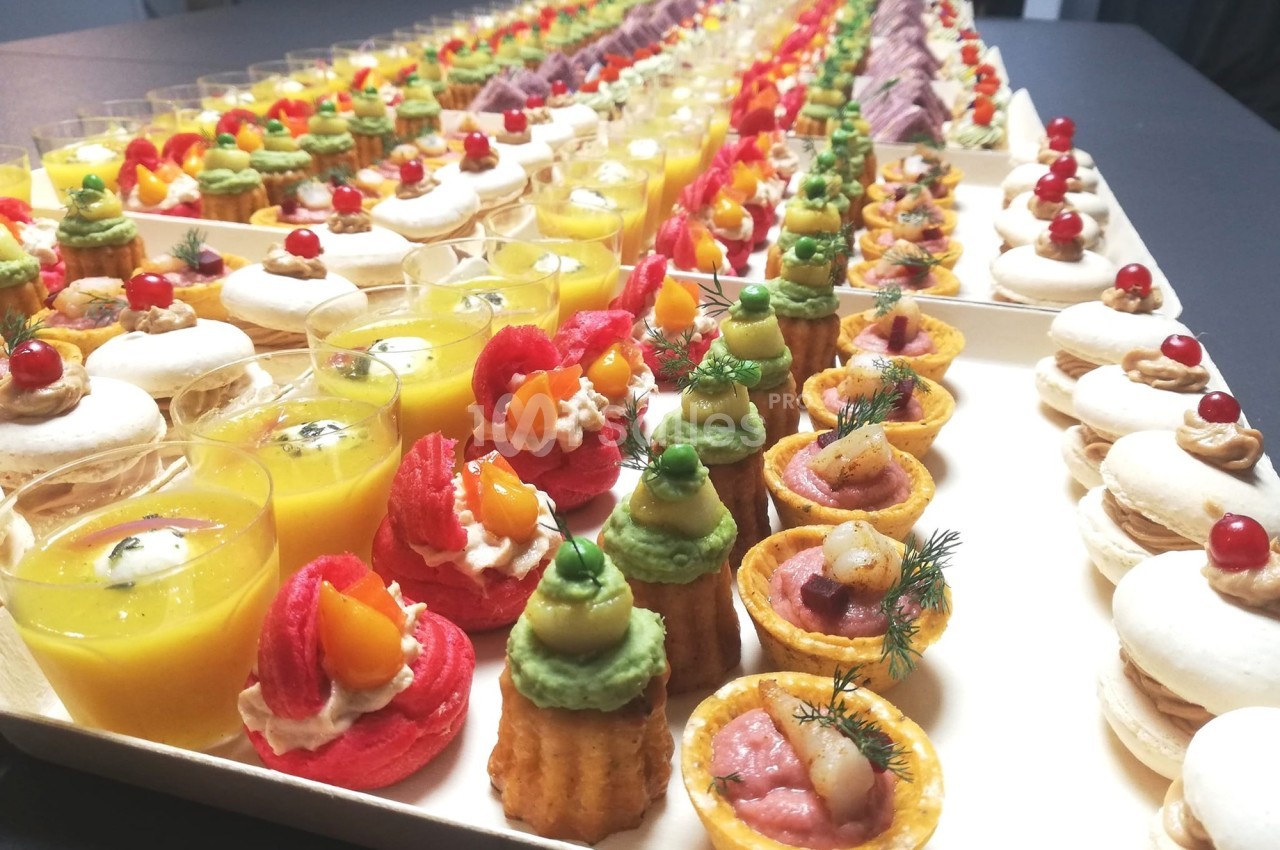 Plateau de bouchées apéritives variées comprenant verrines, macarons salés et mini-tartelettes colorées.