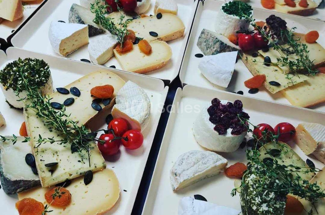Plateaux de fromages variés garnis de fruits secs, tomates cerises et herbes fraîches.
