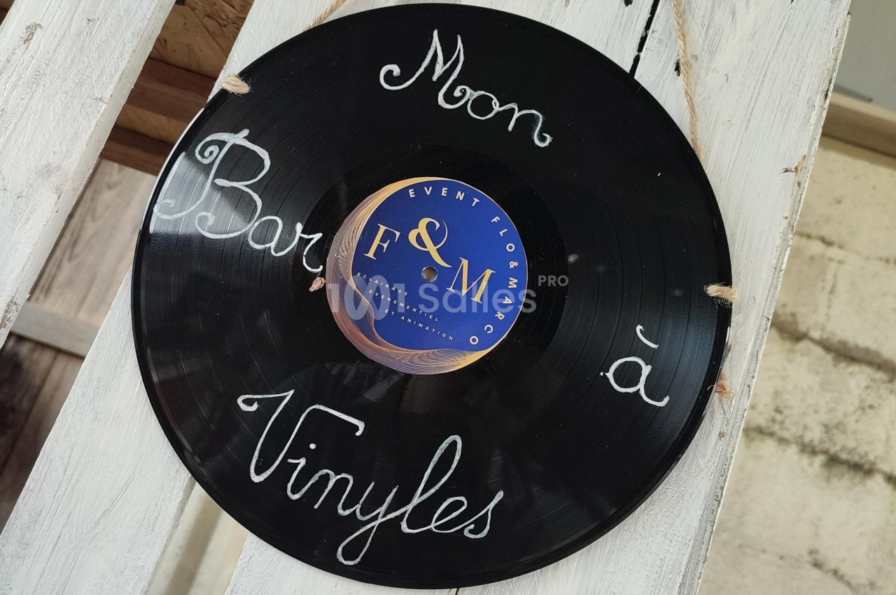 Disque vinyle suspendu avec l'inscription manuscrite ’Mon bar à vinyles’ sur un support en bois.