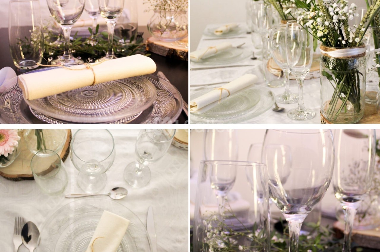 Table dressée avec vaisselle en verre, serviettes pliées, et décorations florales dans un style élégant et naturel.