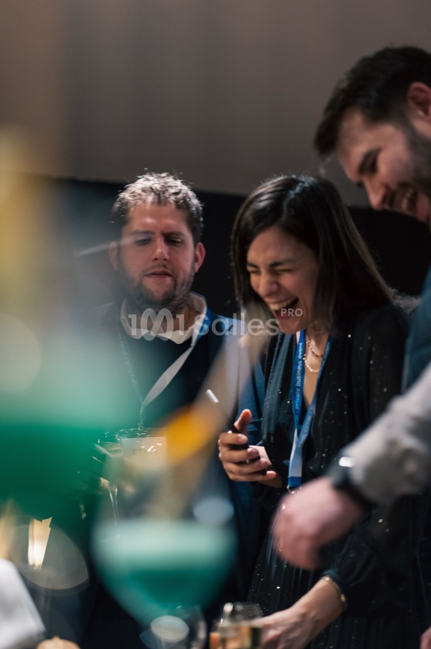 Des personnes souriantes discutent et partagent un moment convivial dans un environnement intérieur.