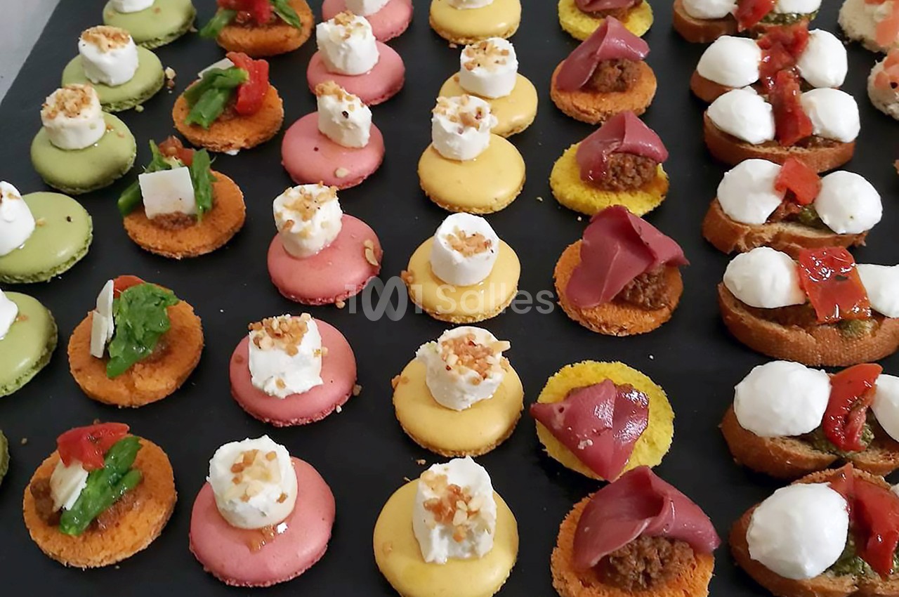 Plateau de bouchées apéritives colorées, comprenant macarons salés et petits toasts garnis de diverses préparations.