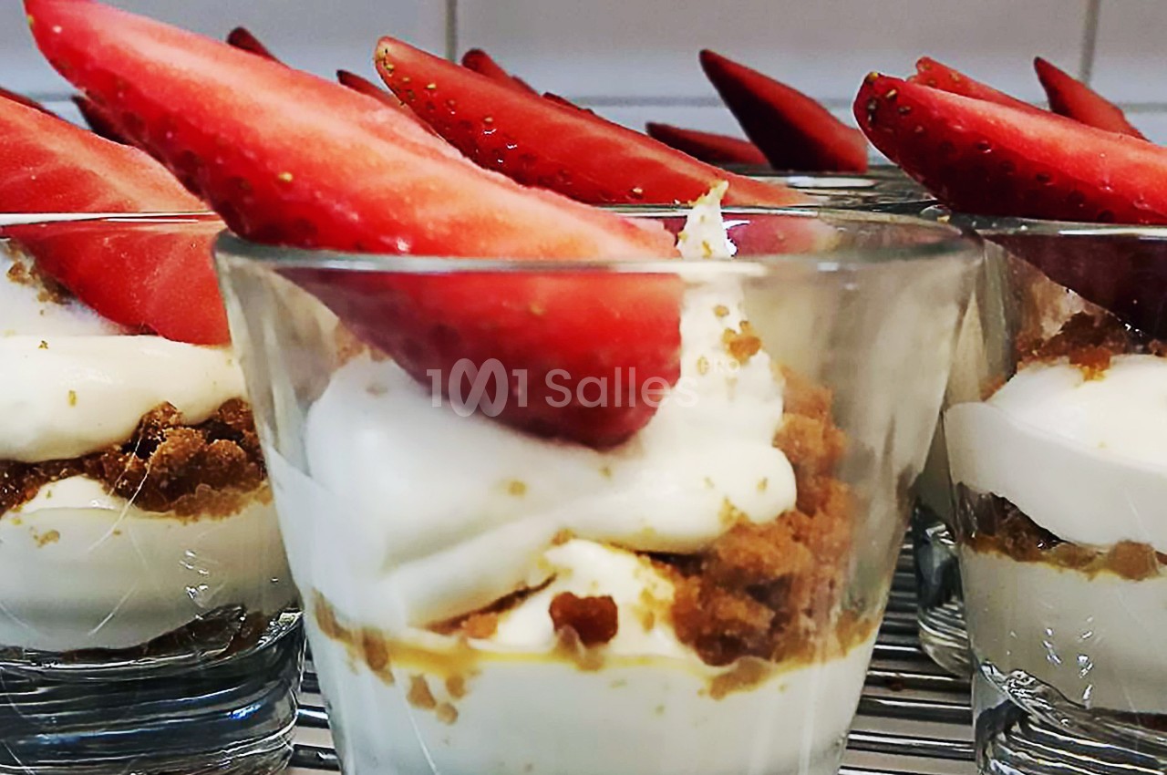 Verrines de dessert composées de crème blanche, miettes de biscuit et quartiers de fraises fraîches.