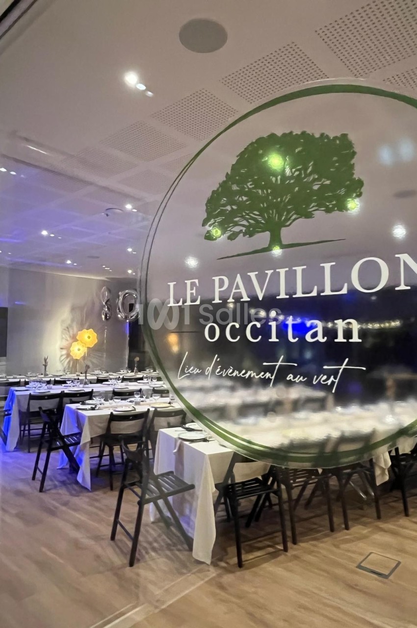 Salle de réception élégamment décorée, vue à travers une vitre avec le logo ’Le Pavillon Occitan’.
