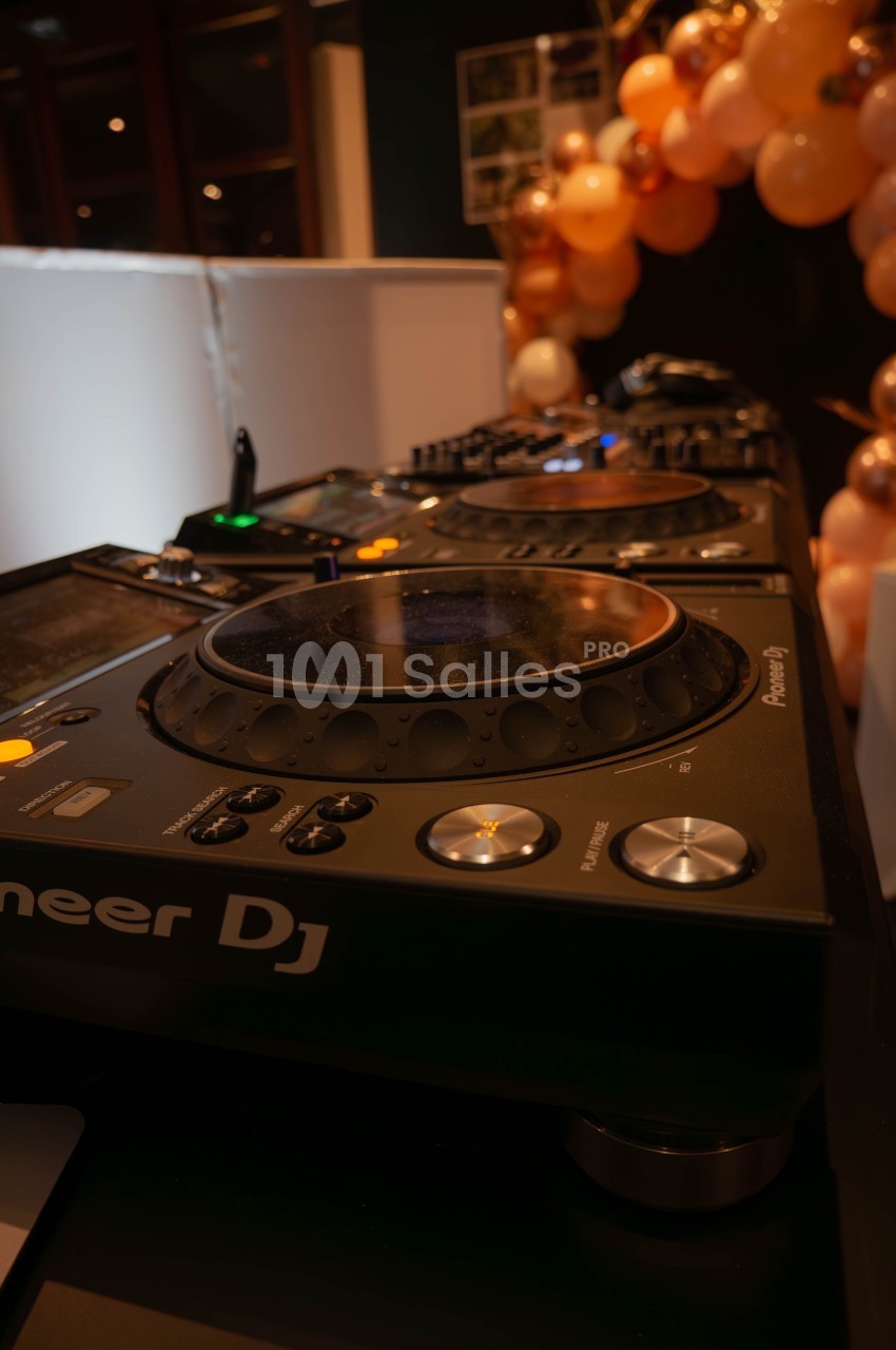 Table de mixage DJ avec platines Pioneer entourée de ballons décoratifs dans un environnement festif.