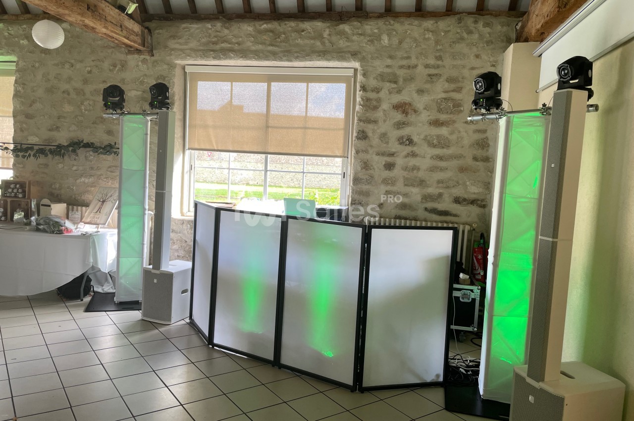 Installation de matériel de sonorisation et éclairage avec projecteurs et panneaux lumineux dans une salle en pierre.
