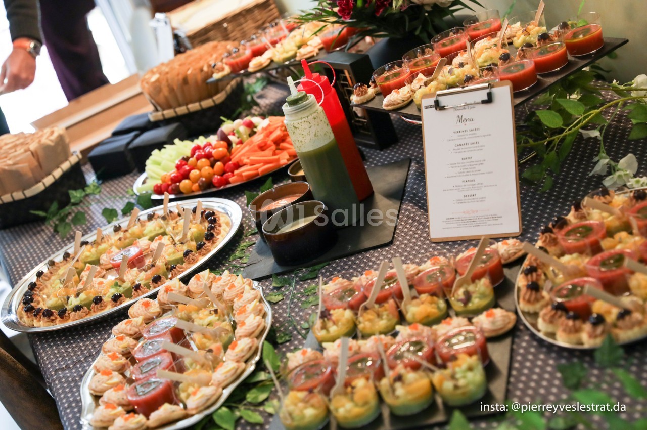 Buffet de plats variés comprenant tartes salées, verrines, légumes frais et sauces, disposés sur une table décorée.