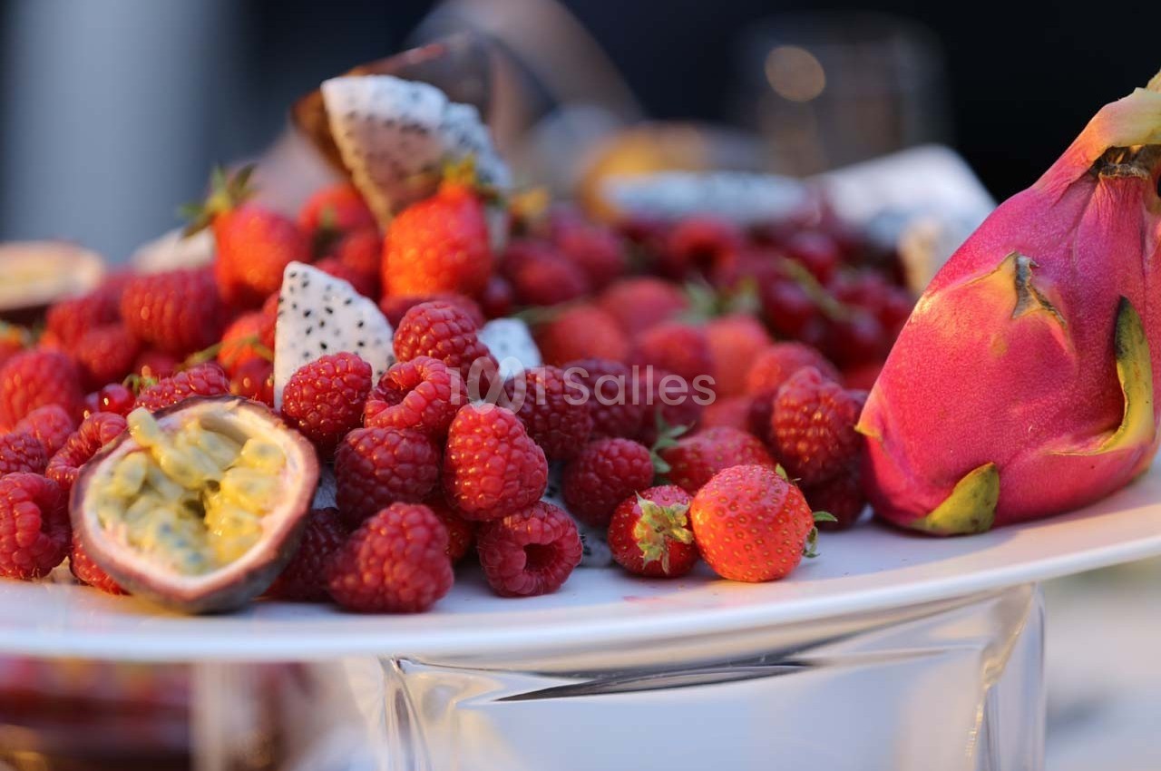 Assortiment de fruits frais comprenant des framboises, des fraises, du fruit du dragon et des fruits de la passion sur un…