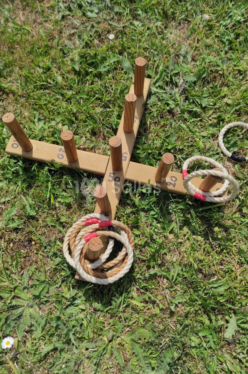 Jeu de lancer d'anneaux en corde sur une structure en bois avec des points marqués, posé sur une pelouse.