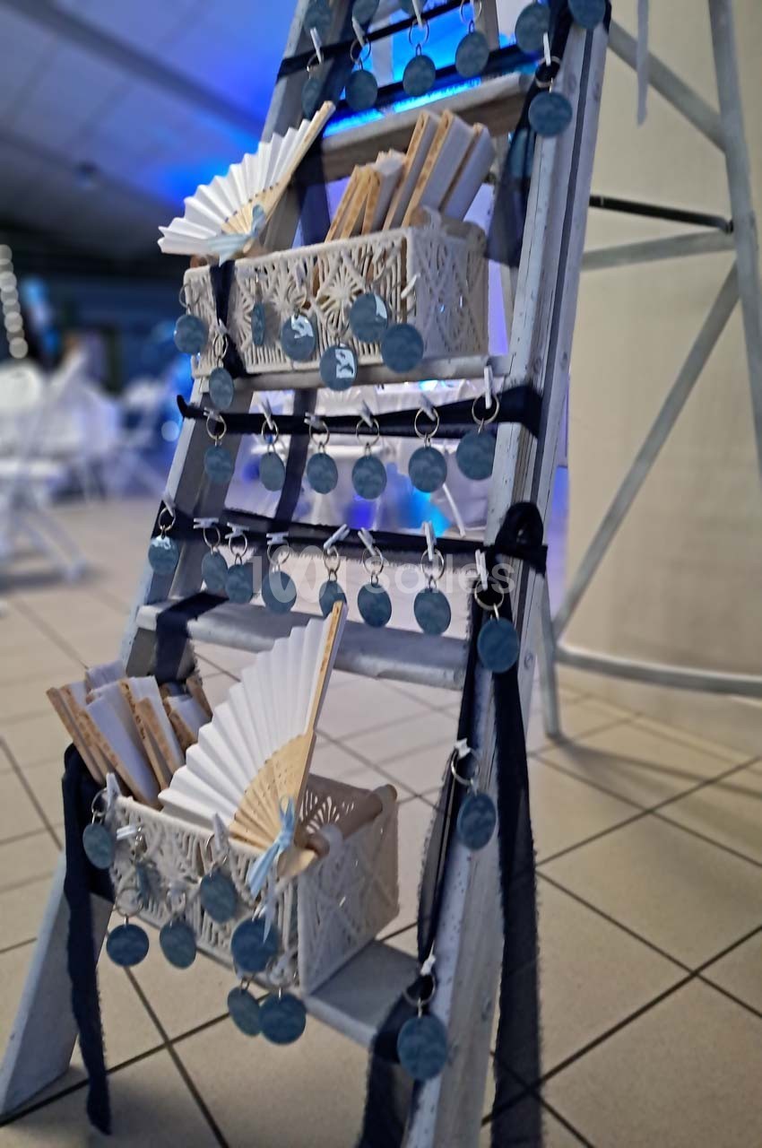Échelle décorative avec des éventails et des médaillons suspendus, disposée dans un espace intérieur lumineux.