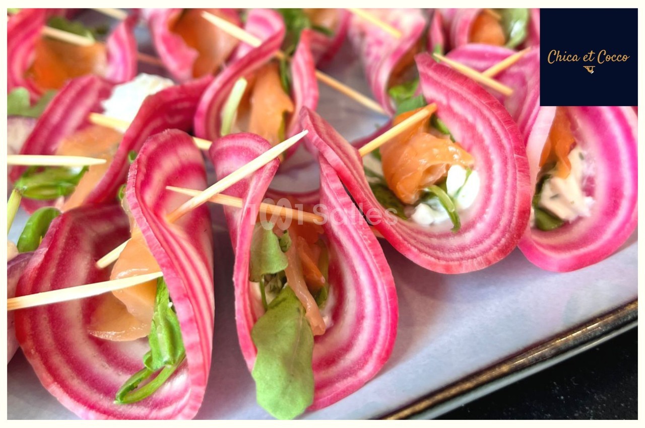 Tranches de betterave chioggia garnies de saumon fumé, fromage frais et roquette, maintenues par des pics en bois.
