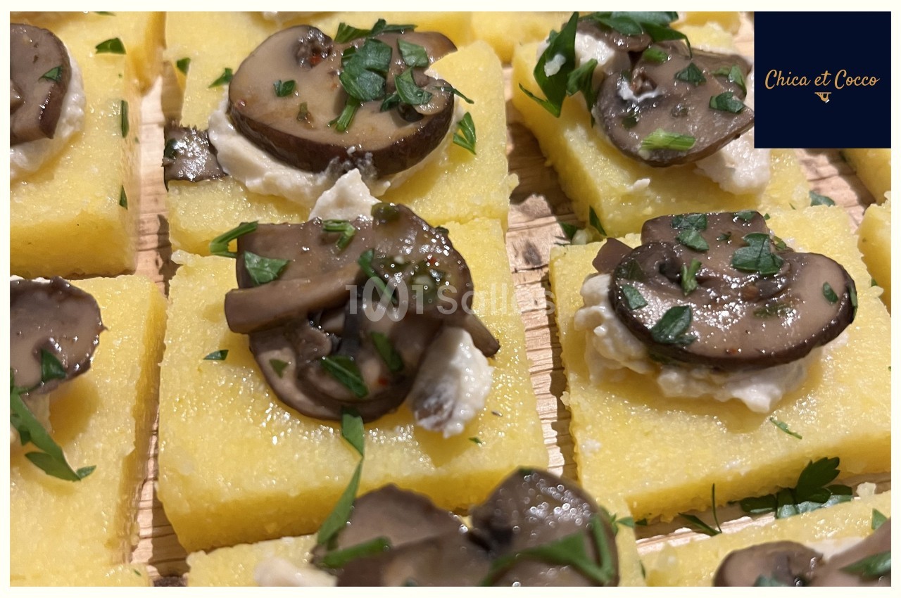 Carrés de polenta garnis de champignons sautés, fromage frais et persil haché.