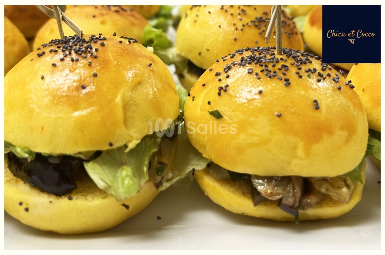Mini burgers garnis de légumes et de salade, présentés sur un plateau avec des piques en bois.