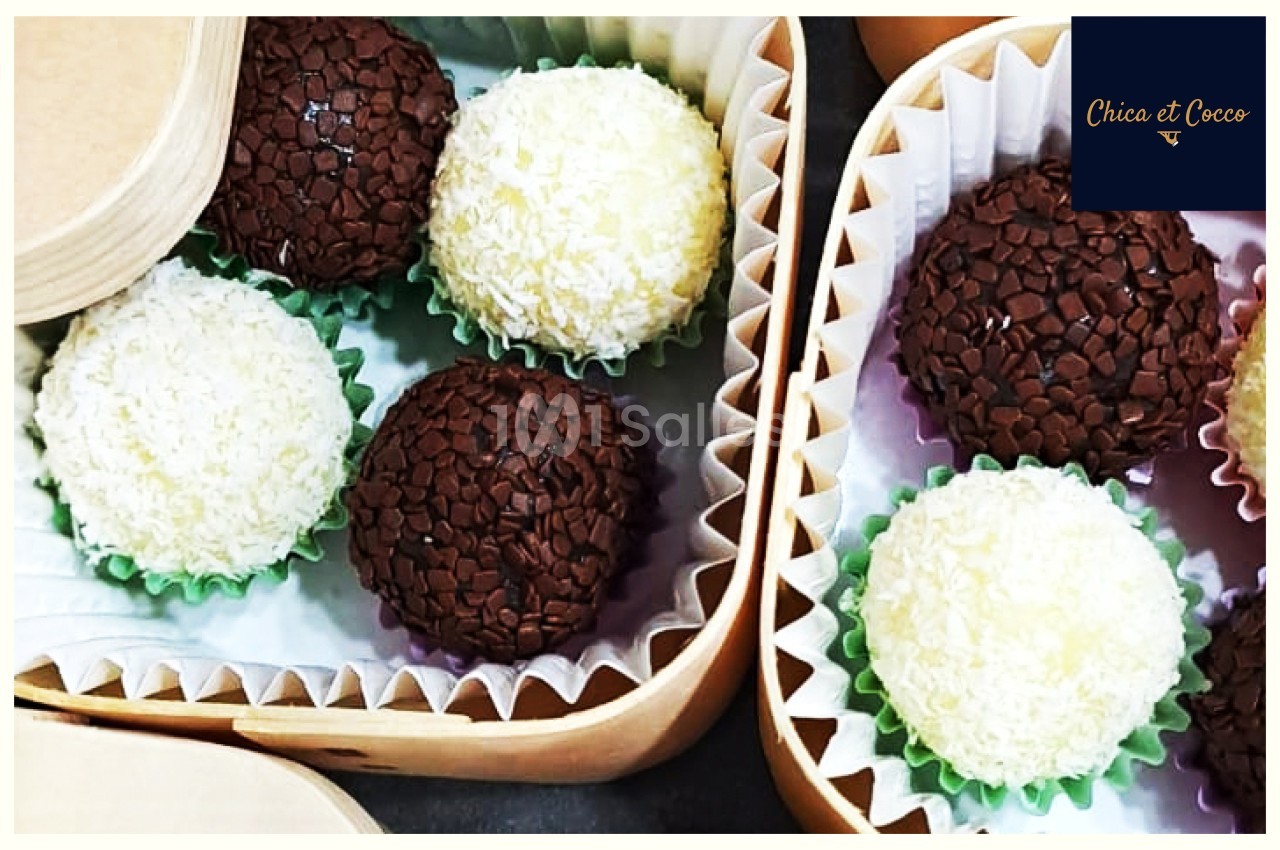 Boules de chocolat et noix de coco présentées dans des boîtes en carton avec caissettes en papier.