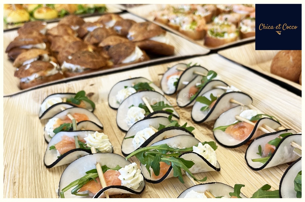 Plateaux de bouchées apéritives variées avec saumon, fromage frais, radis noir et roquette.