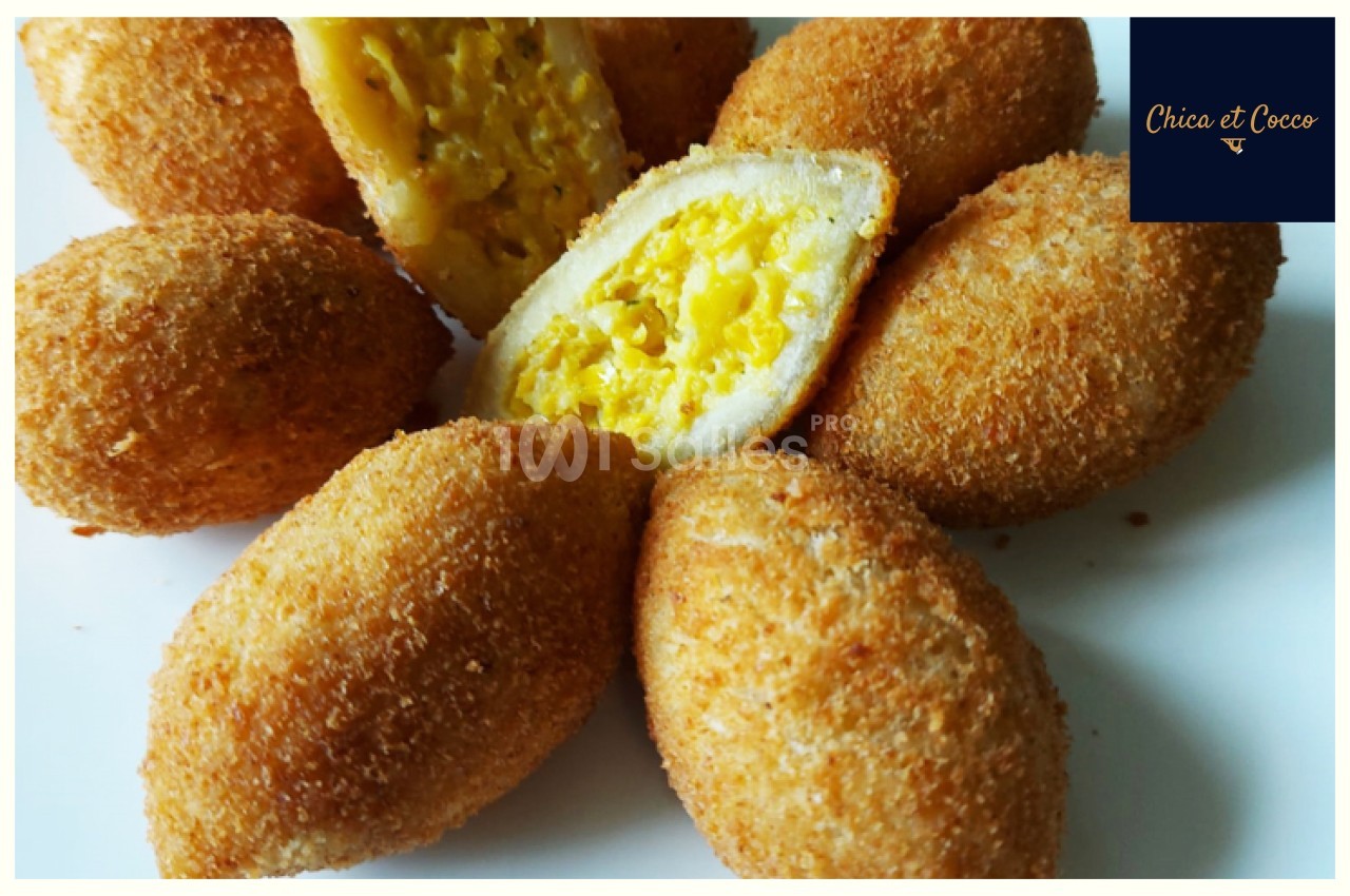 Croquettes dorées et croustillantes, garnies d'une farce jaune crémeuse, présentées sur une assiette blanche.