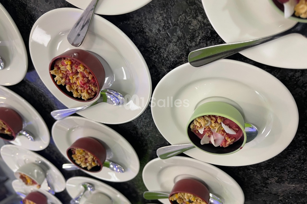 Petits bols en chocolat garnis de fruits rouges et de crumble, disposés sur des assiettes blanches avec des cuillères.