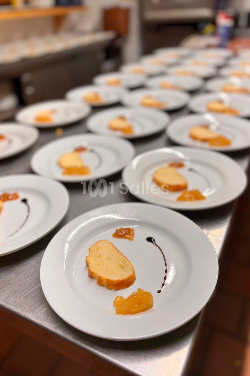 Assiettes alignées contenant une tranche de pain et des condiments, disposées sur un plan de travail en cuisine.