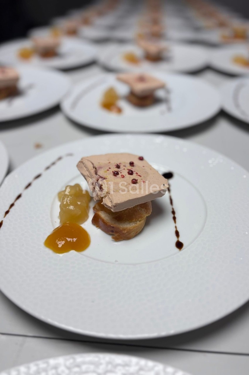 Tranche de foie gras sur pain toasté avec chutney et réduction balsamique, servie sur une assiette blanche.