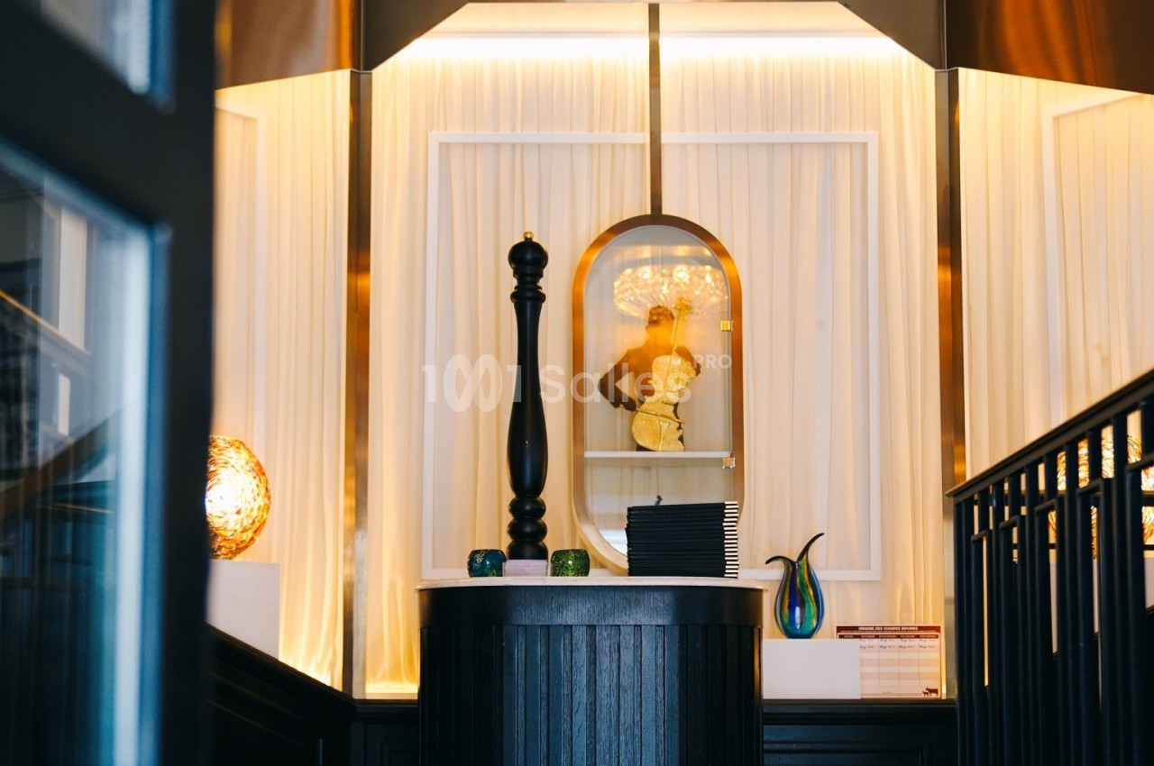 Un comptoir décoratif avec des objets design, éclairé par une lumière chaleureuse et entouré de rideaux blancs.