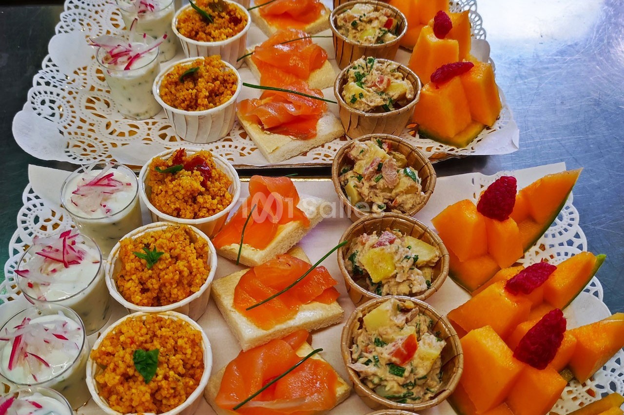 Plateaux de bouchées apéritives variées comprenant saumon, taboulé, rillettes, melon et verrines de sauce.