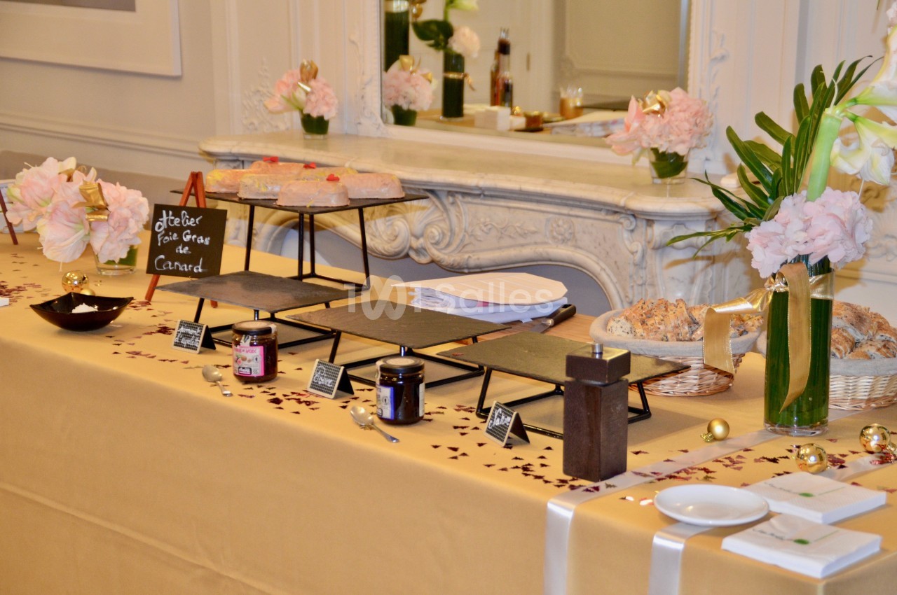 Table de buffet élégante avec foie gras, confitures, pain et décorations florales dans une ambiance raffinée.