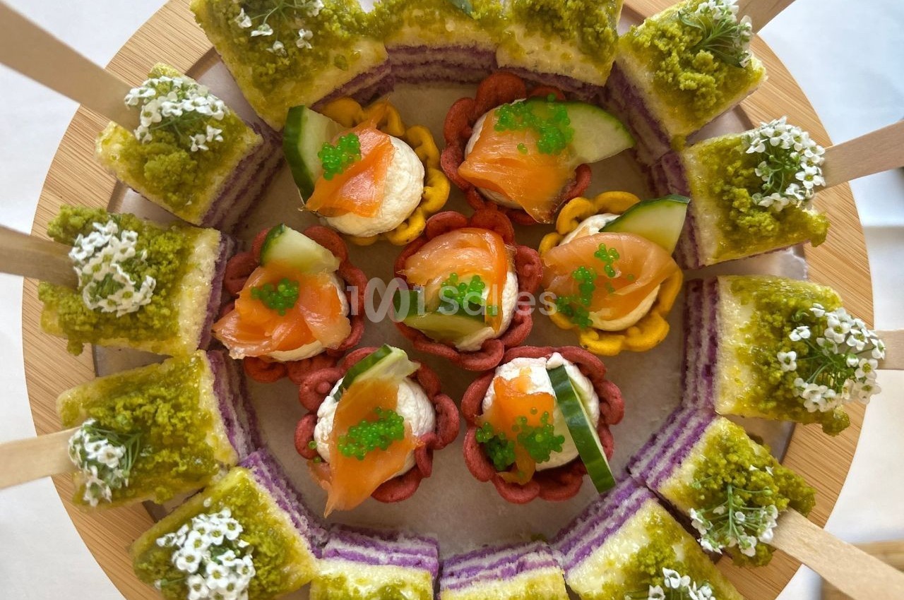 Plateau de bouchées apéritives colorées avec saumon, concombre, œufs de poisson et toasts garnis de mousse verte.