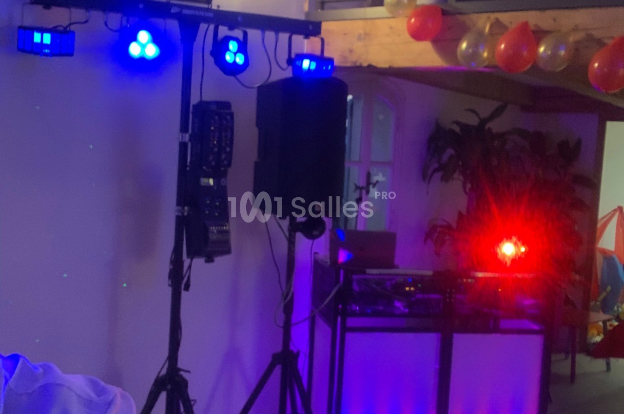 Équipement de sonorisation et éclairage avec projecteurs colorés dans une salle décorée de ballons.
