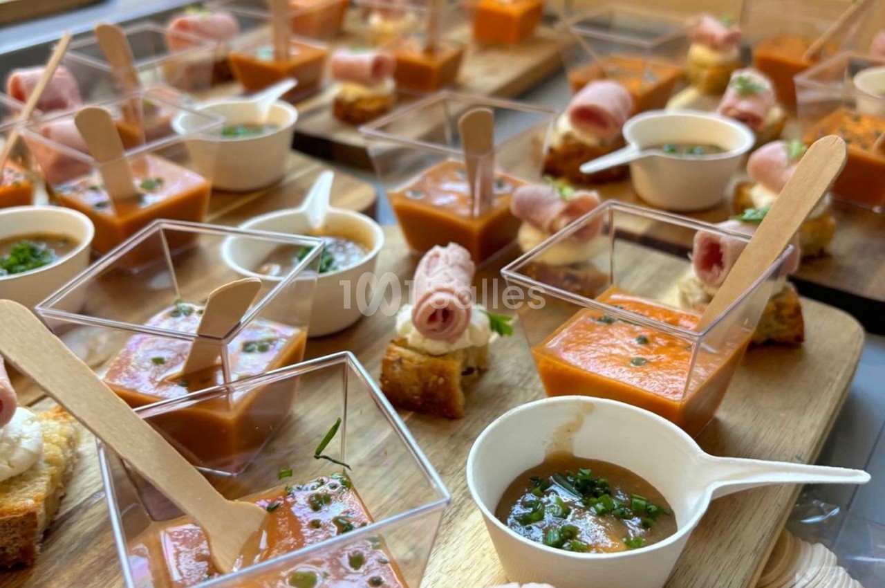 Assortiment de verrines et bouchées apéritives présentées sur des plateaux en bois.
