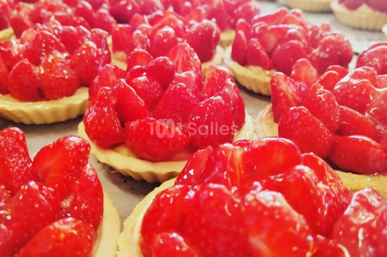 Tartelettes garnies de fraises fraîches et brillantes disposées sur une surface plane.