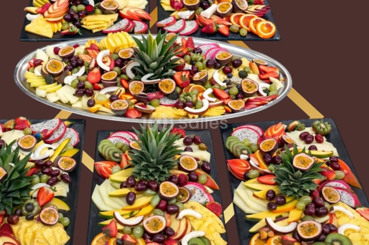 Plateaux de fruits variés avec ananas, kiwis, fruits de la passion, raisins, oranges et autres fruits frais.