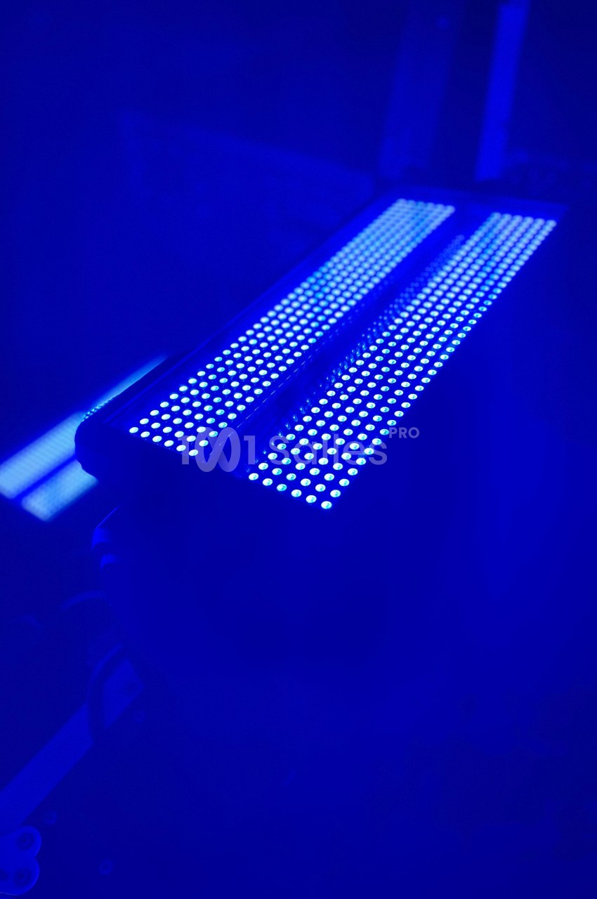 Lampe LED émettant une lumière bleue intense dans un environnement sombre.