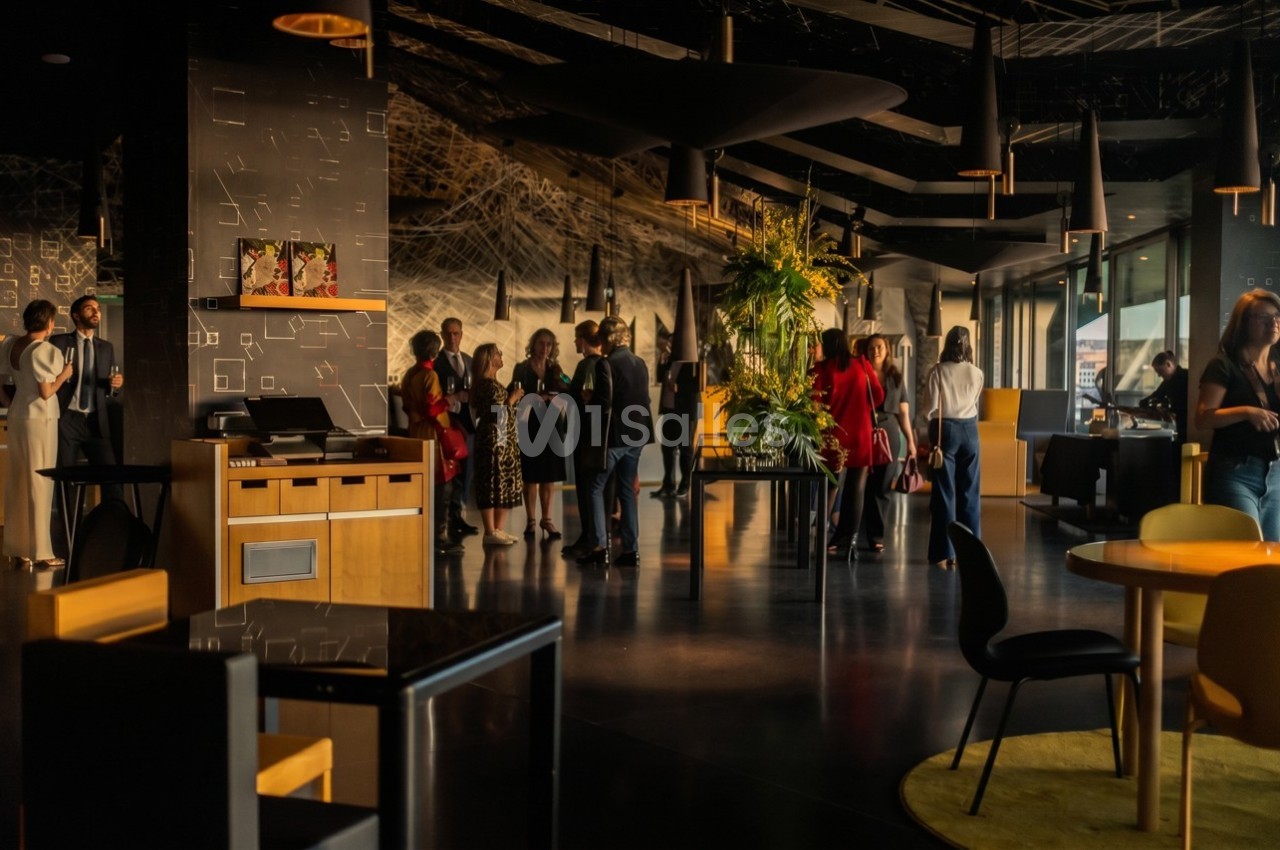 Des personnes discutent dans un espace intérieur moderne avec une décoration élégante et des plantes.