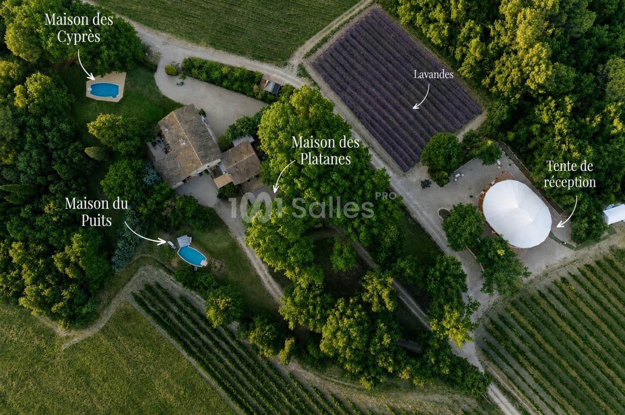 Vue aérienne du domaine avec trois maisons, deux piscines, champs de lavande et tente de réception blanche.