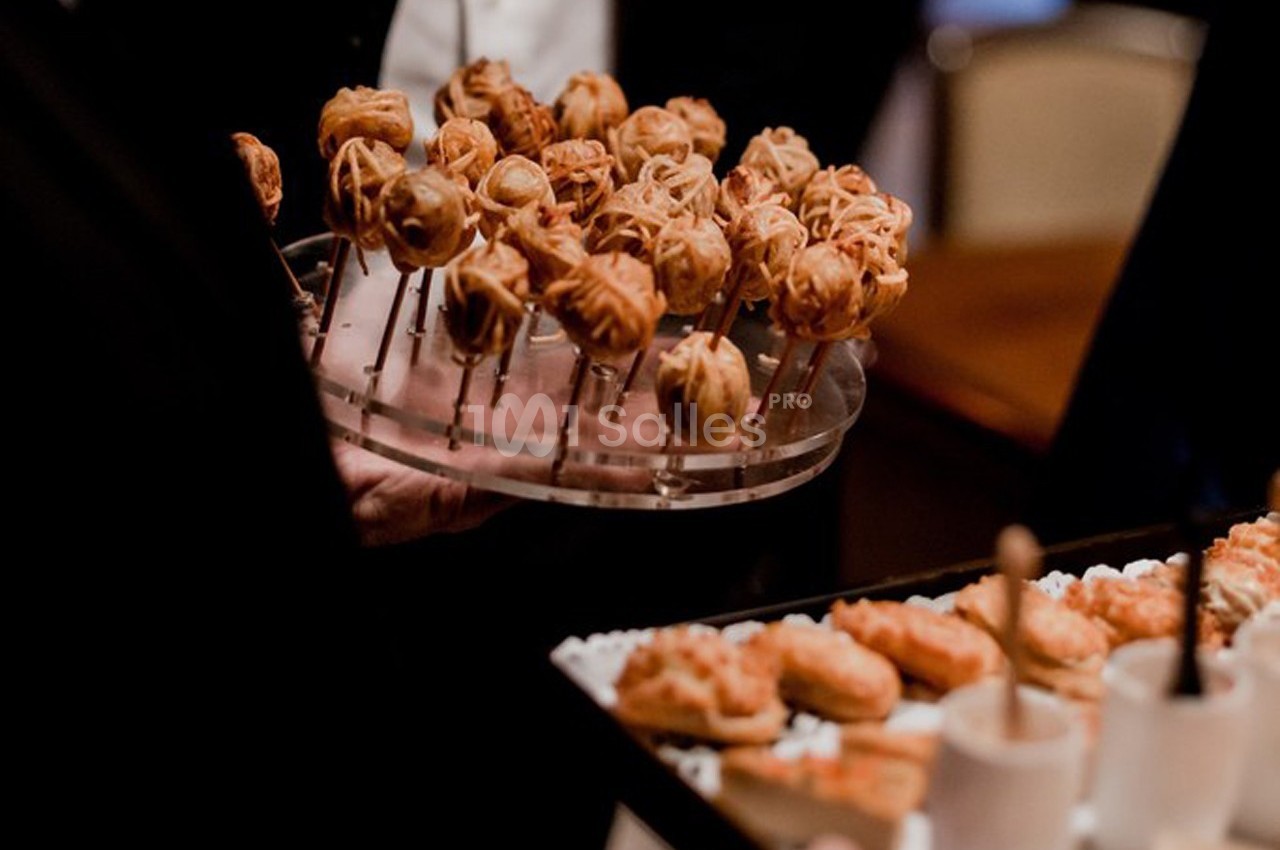 Plateaux de bouchées apéritives variées, dont des brochettes et des verrines, servis lors d'un événement.