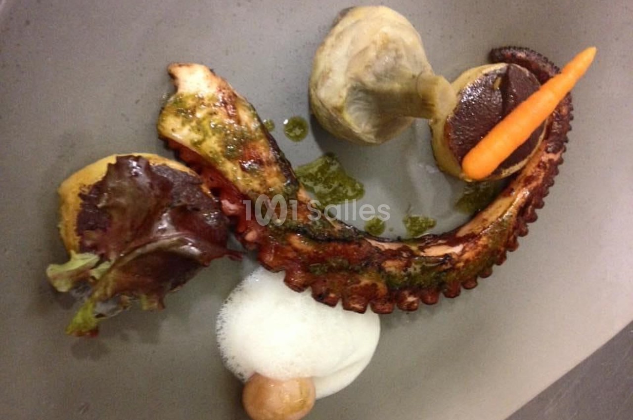 Assiette gastronomique avec tentacule de poulpe grillé, légumes, mousse blanche et sauce verte.