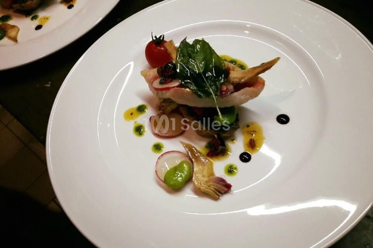 Assiette gastronomique avec filet de poisson, légumes colorés, herbes fraîches et sauces décoratives.