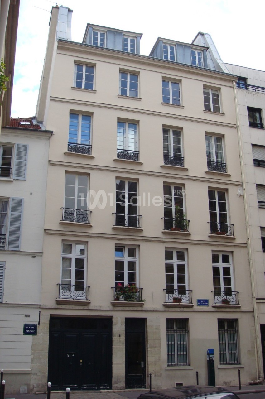 Façade d'un immeuble résidentiel parisien de plusieurs étages avec fenêtres et balcons en fer forgé.