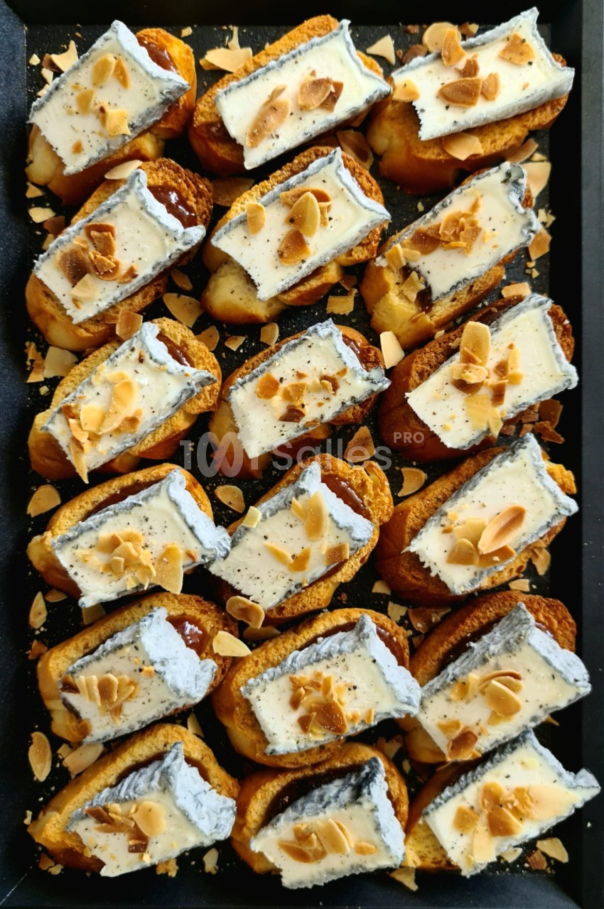 Plateau de petits choux garnis de crème et décorés d'amandes effilées grillées.