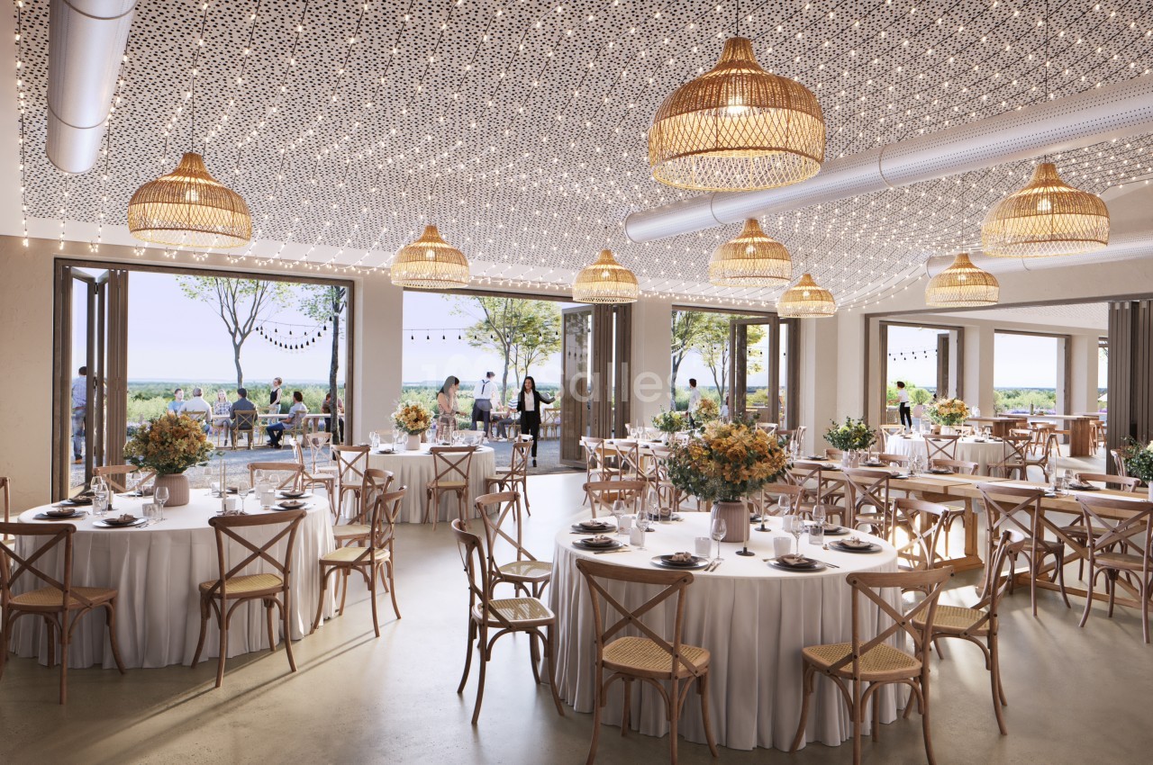 Salle de réception lumineuse avec tables décorées, chaises en bois, suspensions en osier et vue sur une terrasse extérieure.