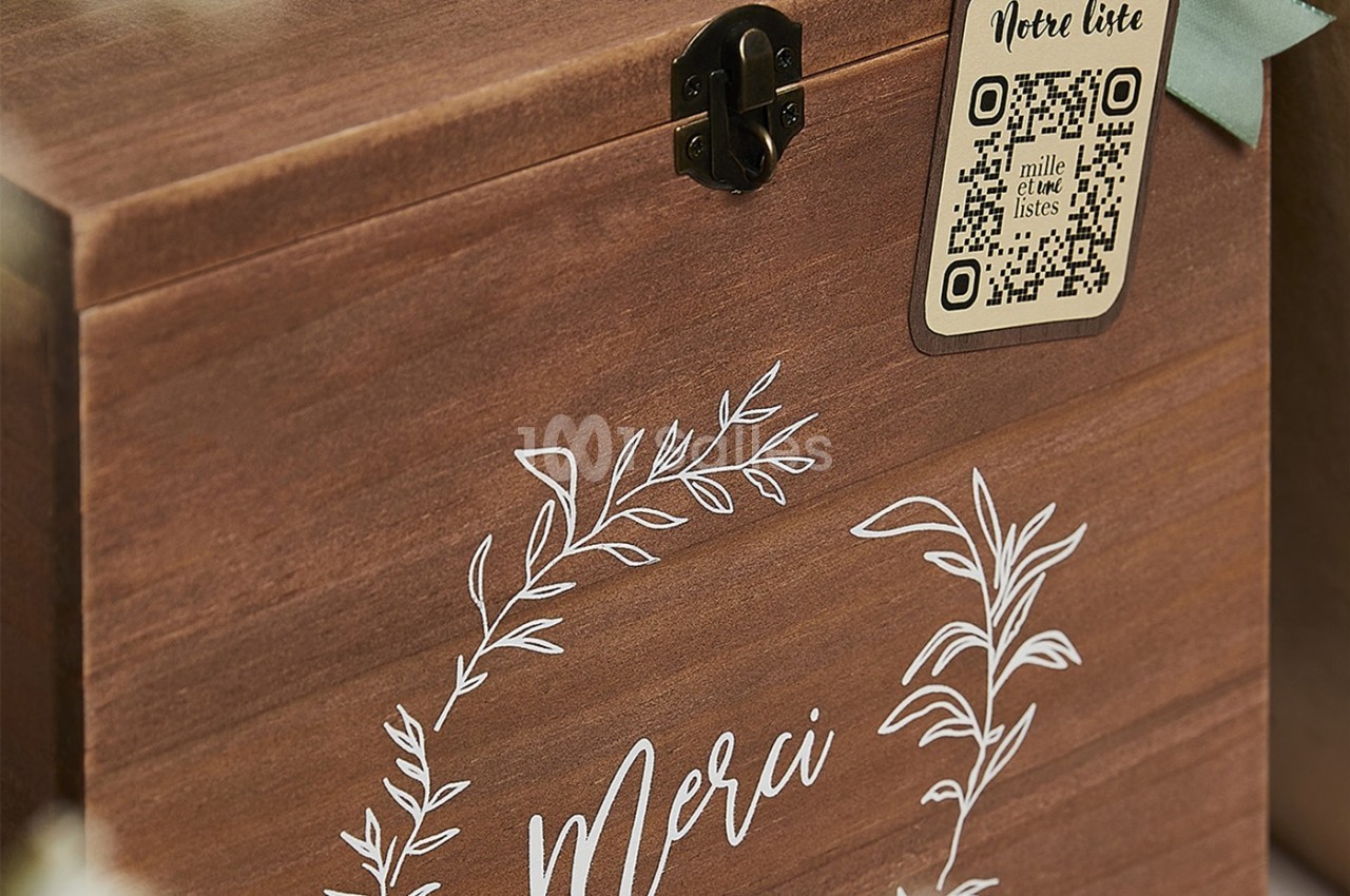 Boîte en bois avec décorations florales blanches, inscription ’Merci’ et étiquette QR code fixée sur le dessus.